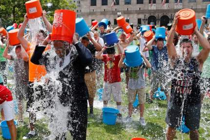 Boston City Councillor Tito Jackson, left in suit, leads some 200 people in the ice bucket challenge at Boston's Copley Square, Thursday, Aug. 7, 2014 to raise funds and awareness for ALS.The idea is easy: Take a bucket of ice water, dump it over your head, video it and post it on social media. Then challenge your friends, strangers, even celebrities to do the same within 24 hours or pay up for charity. (AP Photo/Elise Amendola)